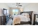 Comfortable main bedroom with dark wood furnishings, ceiling fan and balcony access at 400 150Th Ave # 504, Madeira Beach, FL 33708