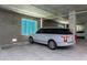 Resident parking space within garage features concrete walls and overhead lighting at 400 150Th Ave # 504, Madeira Beach, FL 33708