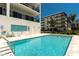 Community pool with chairs and lounge chairs near the building and marina at 400 150Th Ave # 504, Madeira Beach, FL 33708