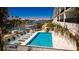 Waterfront condo pool with lounge chairs offers a relaxing outdoor space, with beautiful views of the marina at 400 150Th Ave # 504, Madeira Beach, FL 33708