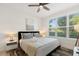 Sunlit bedroom featuring a comfortable bed with plush pillows, complemented by a ceiling fan and large window views at 4913 N Nebraska Ave # 5, Tampa, FL 33603