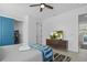 Well-lit bedroom featuring a ceiling fan, wood-look floors, TV, and a blue-accented bunkroom at 4913 N Nebraska Ave # 5, Tampa, FL 33603