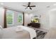 Bedroom with neutral decor, ceiling fan, wood-look floors, TV, and windows showcasing the outside at 4913 N Nebraska Ave # 5, Tampa, FL 33603