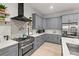 Well-equipped kitchen featuring gray cabinetry, a modern range hood, and stainless steel appliances at 4913 N Nebraska Ave # 5, Tampa, FL 33603