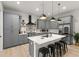 Modern kitchen featuring gray cabinetry, a quartz island with seating, and stainless steel appliances at 4913 N Nebraska Ave # 5, Tampa, FL 33603