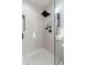 Modern walk-in shower boasts sleek black fixtures and pristine tiling with light flooding in at 4913 N Nebraska Ave # 5, Tampa, FL 33603
