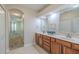 Bright bathroom with double vanity, framed mirrors, and a view into the hallway at 5224 Fairway One Dr, Valrico, FL 33596