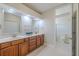 Bright bathroom features a double vanity with framed mirrors and a separate toilet/shower room at 5224 Fairway One Dr, Valrico, FL 33596