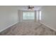 Neutral carpeted bedroom with ceiling fan and natural light from two windows at 5224 Fairway One Dr, Valrico, FL 33596