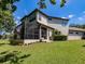 Exterior view of the house showing the back patio, screened in porch, and some yard area at 5224 Fairway One Dr, Valrico, FL 33596