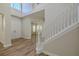 The foyer has lots of natural light, hardwood floors, and a staircase with white wooden trim at 5224 Fairway One Dr, Valrico, FL 33596