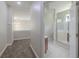 Hallway with an open doorway that leads to a bathroom with a glass door shower at 5224 Fairway One Dr, Valrico, FL 33596