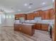 An open floor plan kitchen featuring an island, wood cabinets, and stainless steel appliances at 5224 Fairway One Dr, Valrico, FL 33596