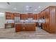 Spacious kitchen featuring cherry cabinets, marble countertops, stainless appliances, and wood flooring at 5224 Fairway One Dr, Valrico, FL 33596