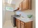 Laundry room with modern appliances, countertop, and overhead cabinets at 5224 Fairway One Dr, Valrico, FL 33596