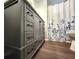 Bathroom featuring an elegant gray vanity with modern hardware and floral shower curtain at 5258 Wisteria Cir, New Port Richey, FL 34653