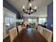 This dining room showcases a wooden table under a chandelier with a window view to the living area at 5258 Wisteria Cir, New Port Richey, FL 34653