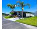 Charming home with a covered carport and beautifully landscaped front yard, enhanced by lush palm trees at 5258 Wisteria Cir, New Port Richey, FL 34653