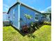 Side yard view of home exterior with vinyl siding and a landscaped garden at 5258 Wisteria Cir, New Port Richey, FL 34653