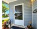 Charming screened front door of a well-maintained home with grey siding and lovely landscaping at 5258 Wisteria Cir, New Port Richey, FL 34653