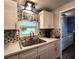 A clean kitchen features white cabinets, a stainless sink with stylish faucet and modern finishes at 5258 Wisteria Cir, New Port Richey, FL 34653