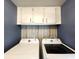 Laundry room features white cabinets above the washer and dryer at 5258 Wisteria Cir, New Port Richey, FL 34653