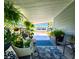 Serene covered porch with cozy seating, potted plants, and tranquil outdoor views at 5258 Wisteria Cir, New Port Richey, FL 34653