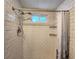 Updated bathroom shower features modern fixtures, subway tile surround, and convenient built-in shelving at 5258 Wisteria Cir, New Port Richey, FL 34653