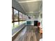 Bright sunroom featuring wood-look flooring, multiple windows, and whimsical decor at 5258 Wisteria Cir, New Port Richey, FL 34653