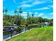 Scenic waterfront view with a boat dock, lush trees, and a vibrant blue sky, creating a tranquil and picturesque setting at 5258 Wisteria Cir, New Port Richey, FL 34653