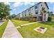 New construction exterior showcasing modern townhomes with manicured lawns and a sidewalk view at 532 W Plaza Pl # 3, Tampa, FL 33602