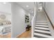 Bright hallway featuring hardwood floors, staircase, bench, and artwork leading to the bedroom at 532 W Plaza Pl # 3, Tampa, FL 33602