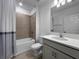 Bright bathroom with a shower-tub combo, neutral tile, and a gray vanity at 5336 Patano Loop, Palmetto, FL 34221