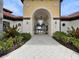 A view of the clubhouse entrance with an arched entryway, tiled walkway, and well-maintained landscaping at 5336 Patano Loop, Palmetto, FL 34221