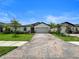 Wide front exterior shot showcasing a home with a paved driveway, manicured lawn, and tasteful landscaping at 5336 Patano Loop, Palmetto, FL 34221