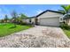 Exterior view of home showing the garage and tropical landscaping at 5336 Patano Loop, Palmetto, FL 34221