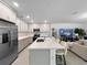 Bright, open kitchen featuring stainless steel appliances, a large island, and seamless integration with the living room at 5336 Patano Loop, Palmetto, FL 34221