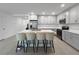 Bright kitchen with a large center island with seating, stainless steel appliances, and modern gray cabinets at 5336 Patano Loop, Palmetto, FL 34221