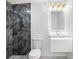 Modern bathroom featuring gray marble-look tile shower, white vanity, illuminated mirror, and hexagon tile floor at 5618 Halifax Dr, Tampa, FL 33615