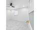 Bright bedroom showcasing marble-look tile flooring, a modern ceiling fan, recessed lighting, and a sleek door at 5618 Halifax Dr, Tampa, FL 33615