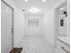 Bright entryway features marble-look tile flooring, modern light fixture, and white front door at 5618 Halifax Dr, Tampa, FL 33615