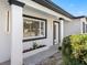 Close-up of the front entrance featuring new energy-efficient lighting, windows and white door at 5618 Halifax Dr, Tampa, FL 33615