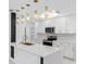Stylish kitchen features an island with quartz countertop, decorative pendant lights, and stainless appliances at 5618 Halifax Dr, Tampa, FL 33615