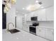 Clean, modern kitchen with white cabinets, quartz countertops, stainless appliances, and stylish lighting at 5618 Halifax Dr, Tampa, FL 33615