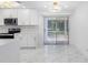 Spacious kitchen features stainless appliances, white cabinetry, quartz countertops and sliding glass doors at 5618 Halifax Dr, Tampa, FL 33615