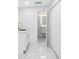 Room with a closet, utility sink and a bathroom, all finished with white trim and marble floors at 5618 Halifax Dr, Tampa, FL 33615