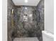 Modern shower with sleek gray tiling, gold fixtures, and a convenient built-in shelf at 5618 Halifax Dr, Tampa, FL 33615