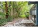 Lush backyard with tropical foliage and paver patio offers a private outdoor retreat adjacent to screened in lanai at 60 Birdsong Ct, Oldsmar, FL 34677