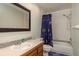 Charming bathroom featuring a vanity with mosaic detail, toilet, and a tub-shower combination with a decorative curtain at 60 Birdsong Ct, Oldsmar, FL 34677