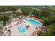 Aerial of a community pool featuring lap lanes, a ' pool, seating, and landscaping for Gathering fun at 60 Birdsong Ct, Oldsmar, FL 34677